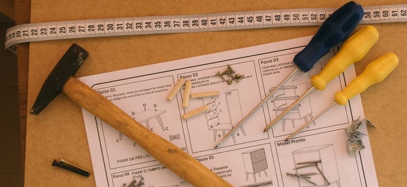 Photo of a hammer and tools lying on a workbench