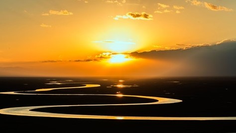 Photo of a river reflecting the golden light of a sunset