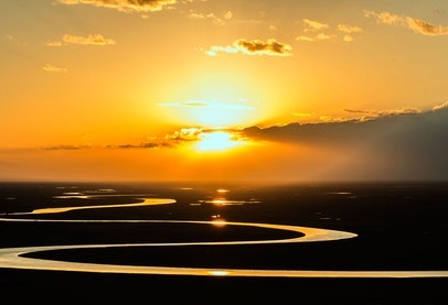 Photo of a river reflecting the golden light of a sunset